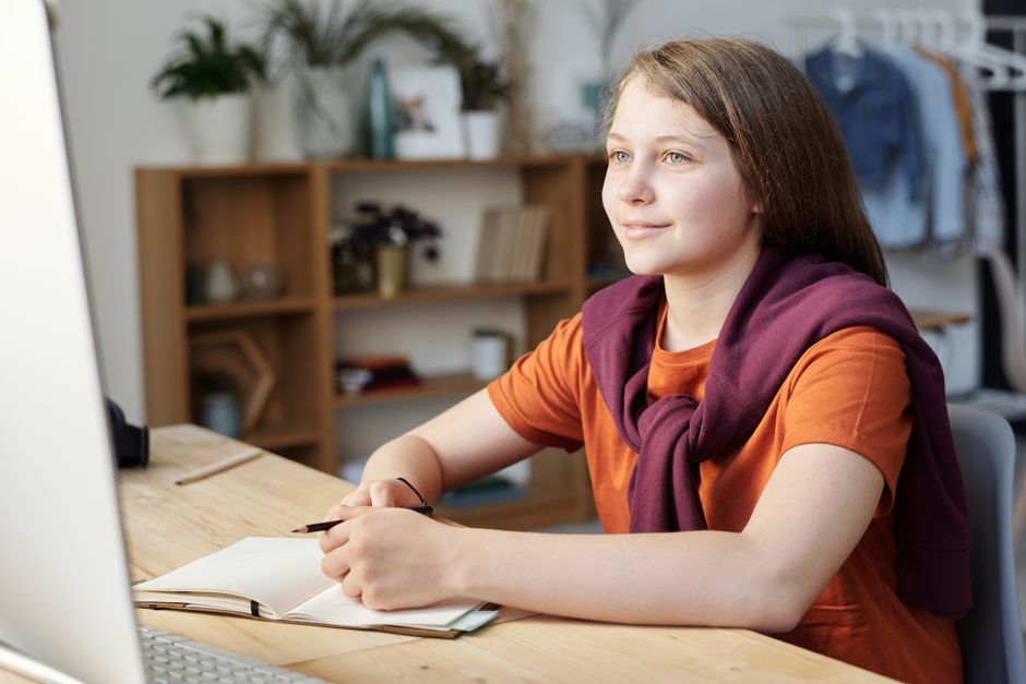 Child checking morning tasks on a tablet at the breakfast table Child checking morning tasks on a tablet at the breakfast table