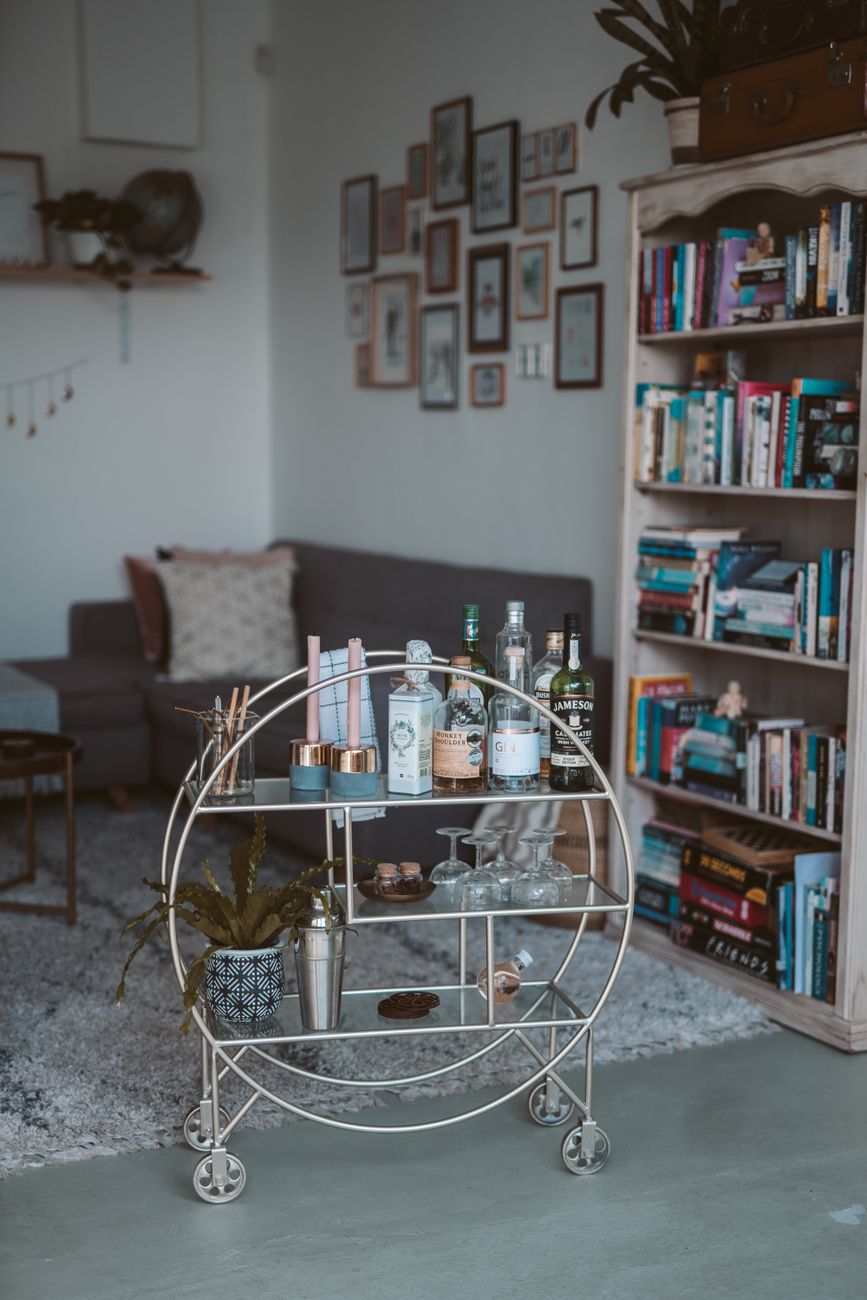 A well-organised bar cart standing ready in a modern living room