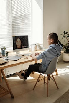 Teenage boy participating in online education at home on a desktop computer.