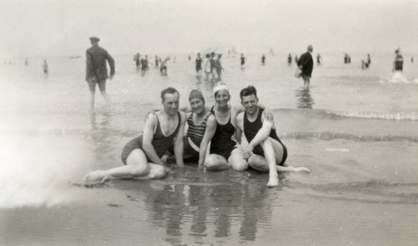 A charming black and white photograph of friends in swimsuits enjoying a day at the beach, showcasing vintage swimwear style.