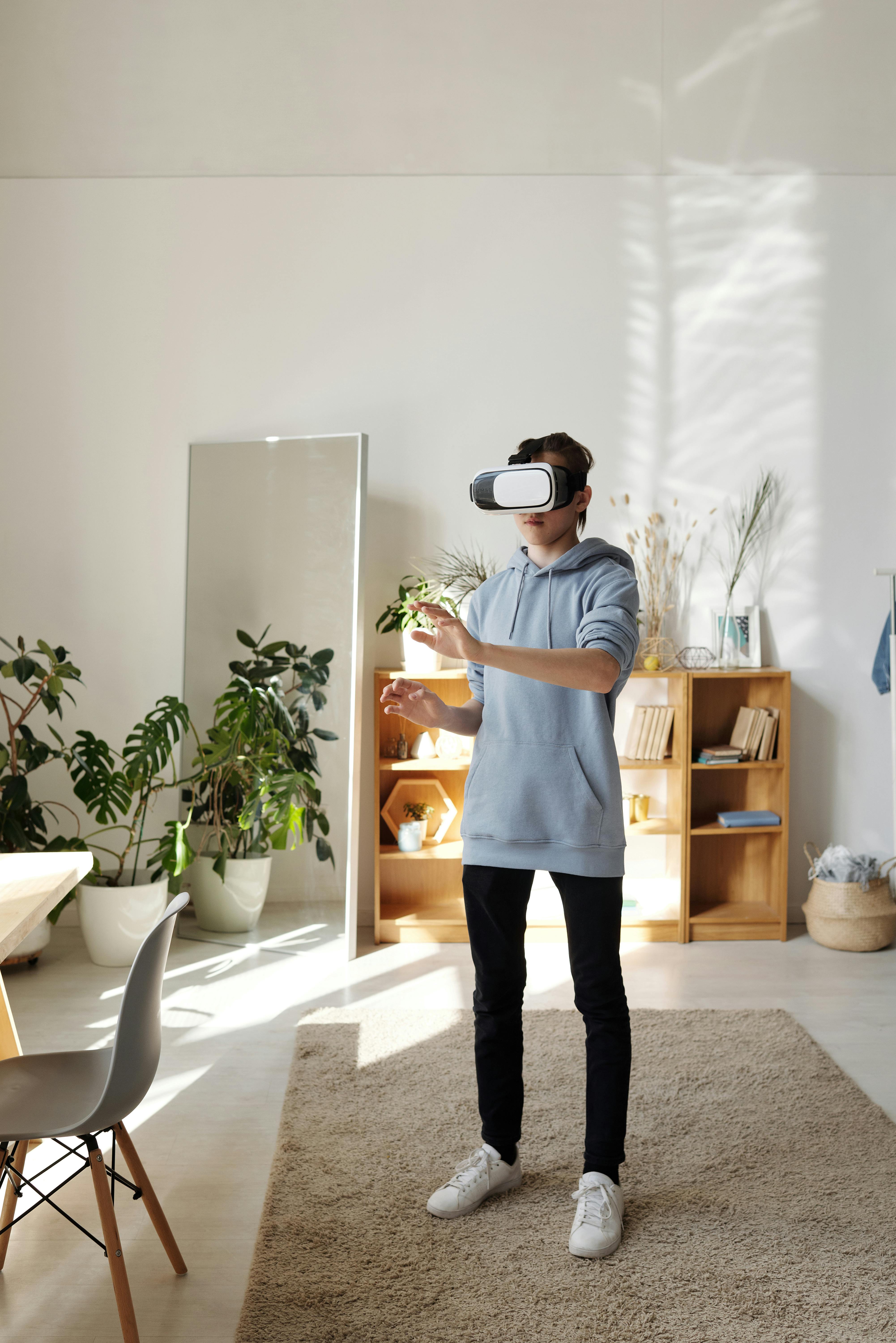 photo of boy standing while using vr headset