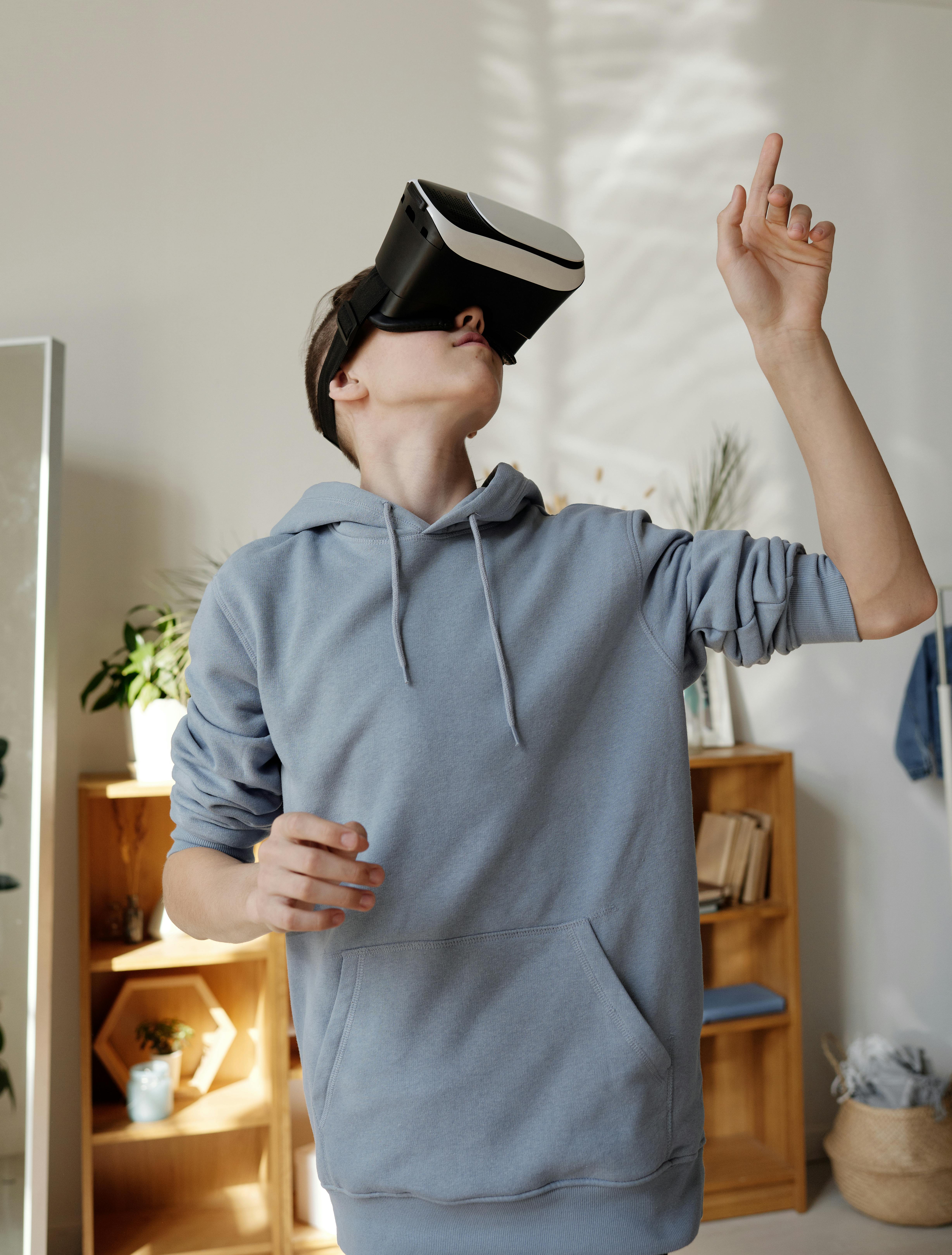 boy in gray hoodie wearing vr headset