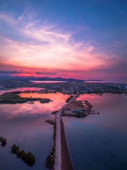 A breathtaking aerial view of a vibrant sunrise reflecting over calm waters in Masbate City, Philippines.