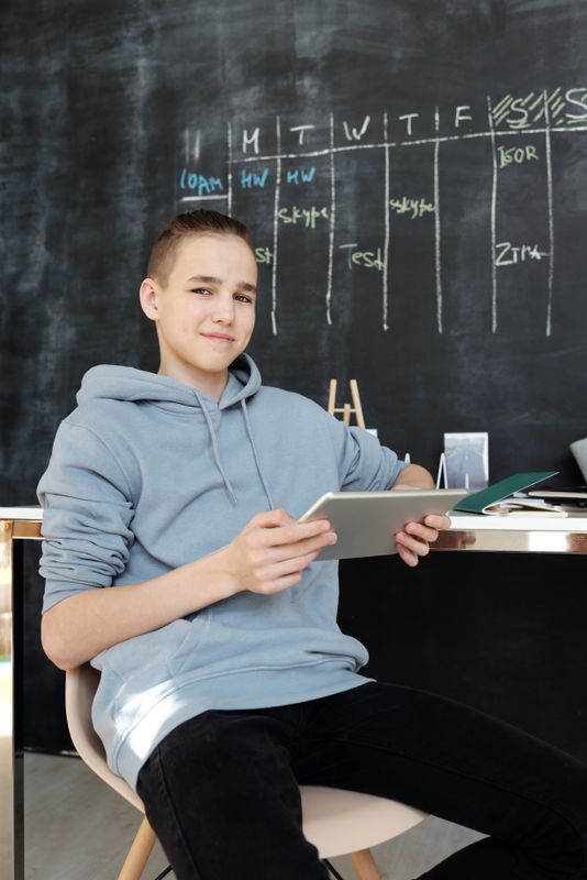 Teen studying with tablet in modern setup