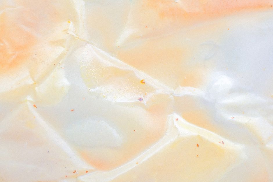 A close-up view of crumpled pastel paper showcasing intricate textures and soft hues.