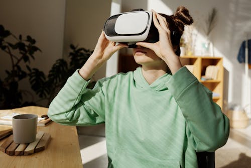 A Woman in Green Sweater Using Virtual Reality Goggles