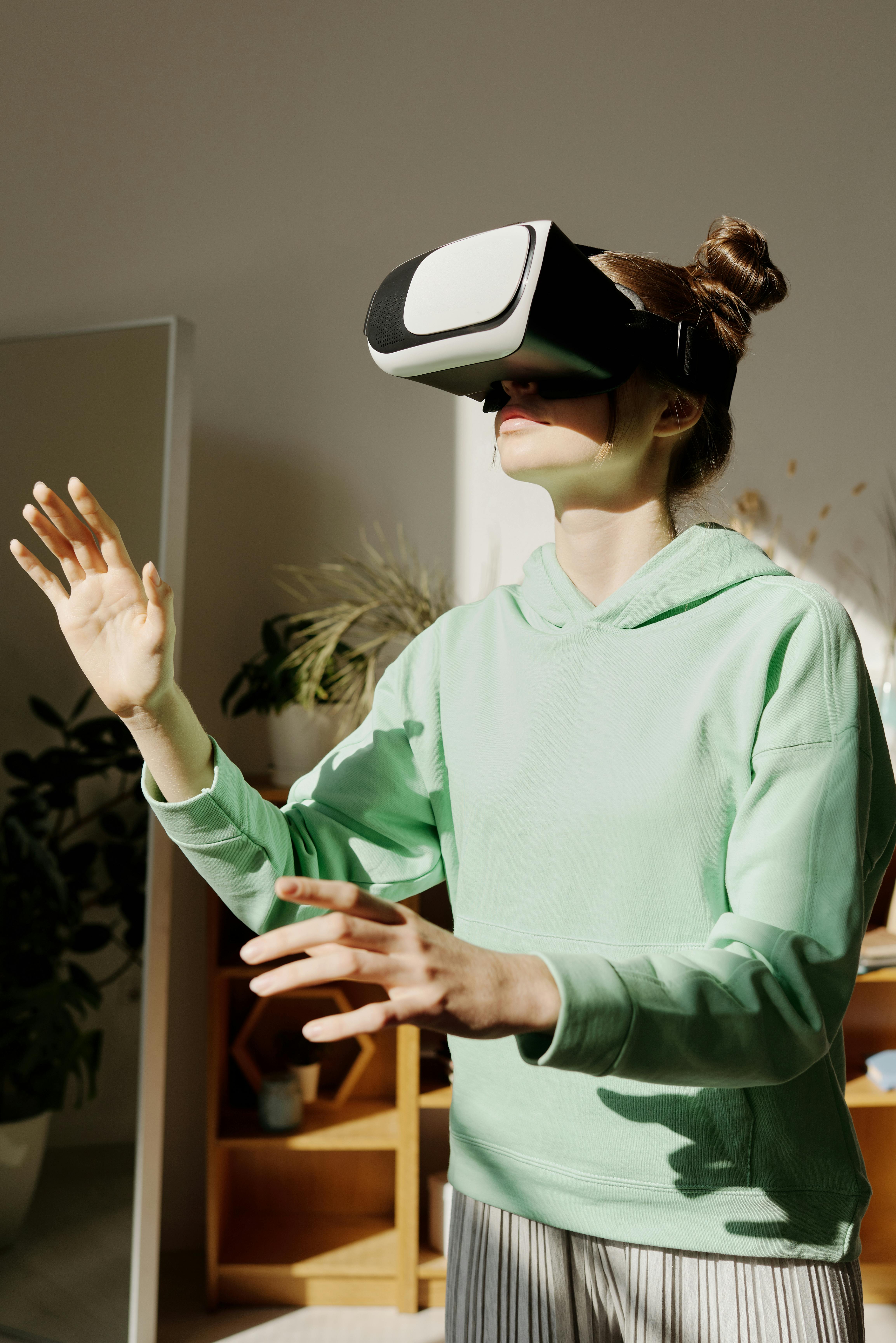 woman in green hoodie using a virtual reality headset