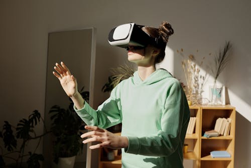 Teenage Girl in Green Hoodie Using a Virtual Reality Headset