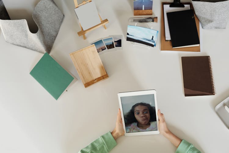 Hands Holding Tablet With Girl On Screen