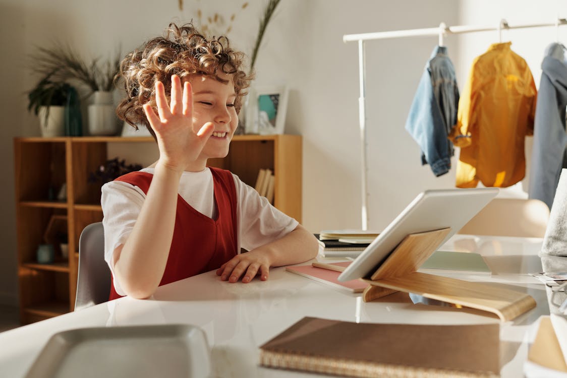 Free Photo of Child Smiling While Using Tablet Computer Stock Photo