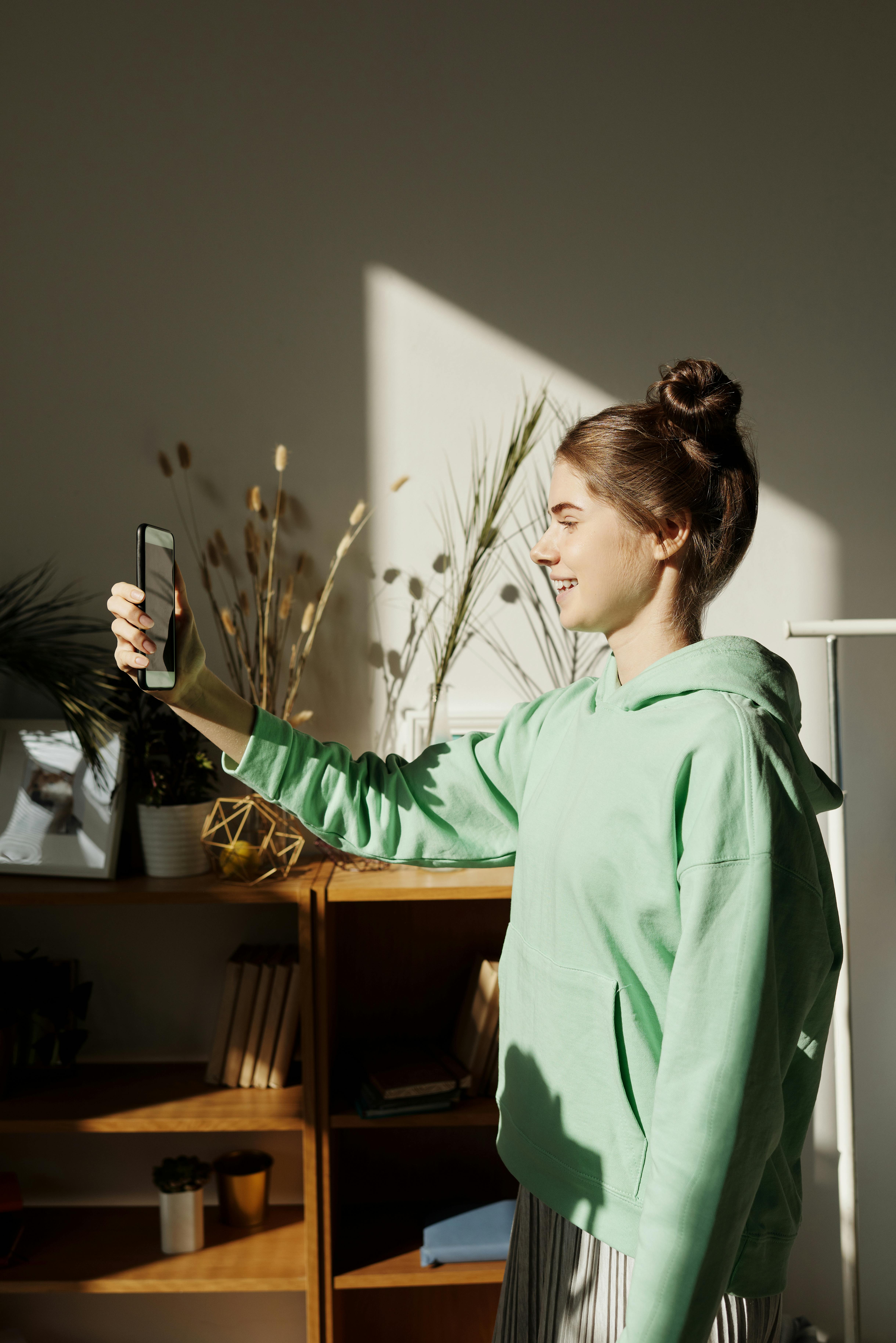 photo of girl taking photo using smartphone