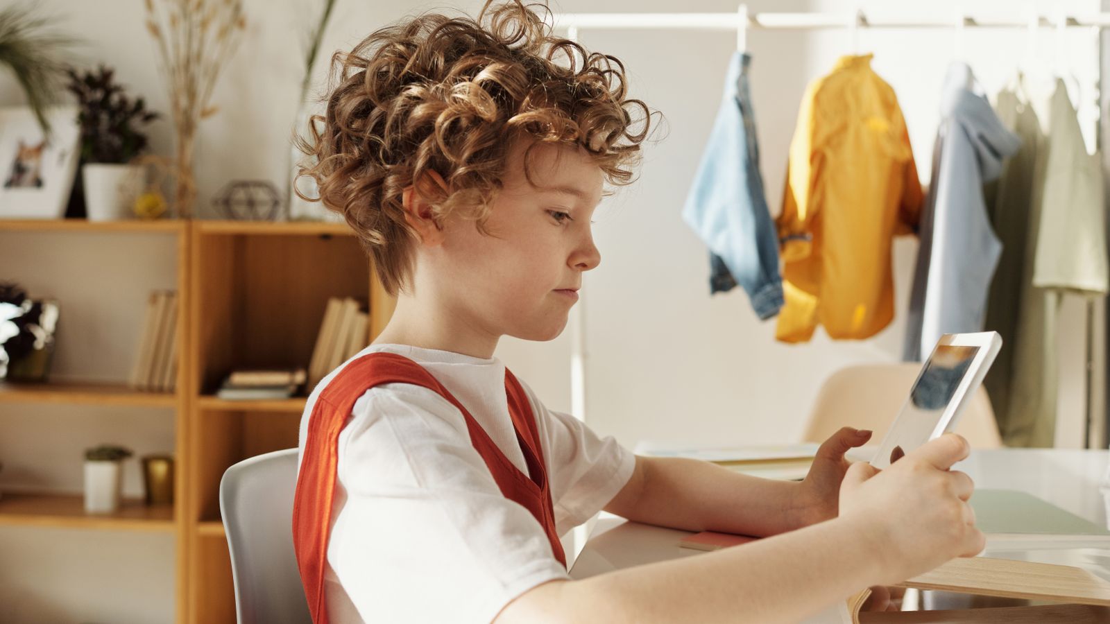 A child using a tablet under adult supervision, illustrating safe AI for teaching English to kids