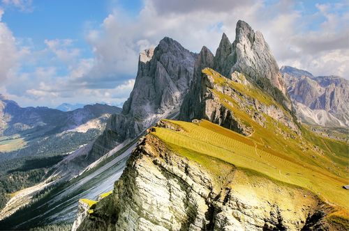 Free A breathtaking view of jagged mountain peaks and lush valleys under a vibrant blue sky. Stock Photo