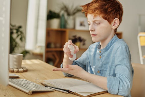 Photo of Boy Using Hand Sanitizer