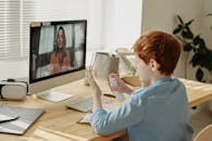 一个小男孩在办公桌前使用电脑进行在线学习，并涂抹洗手液