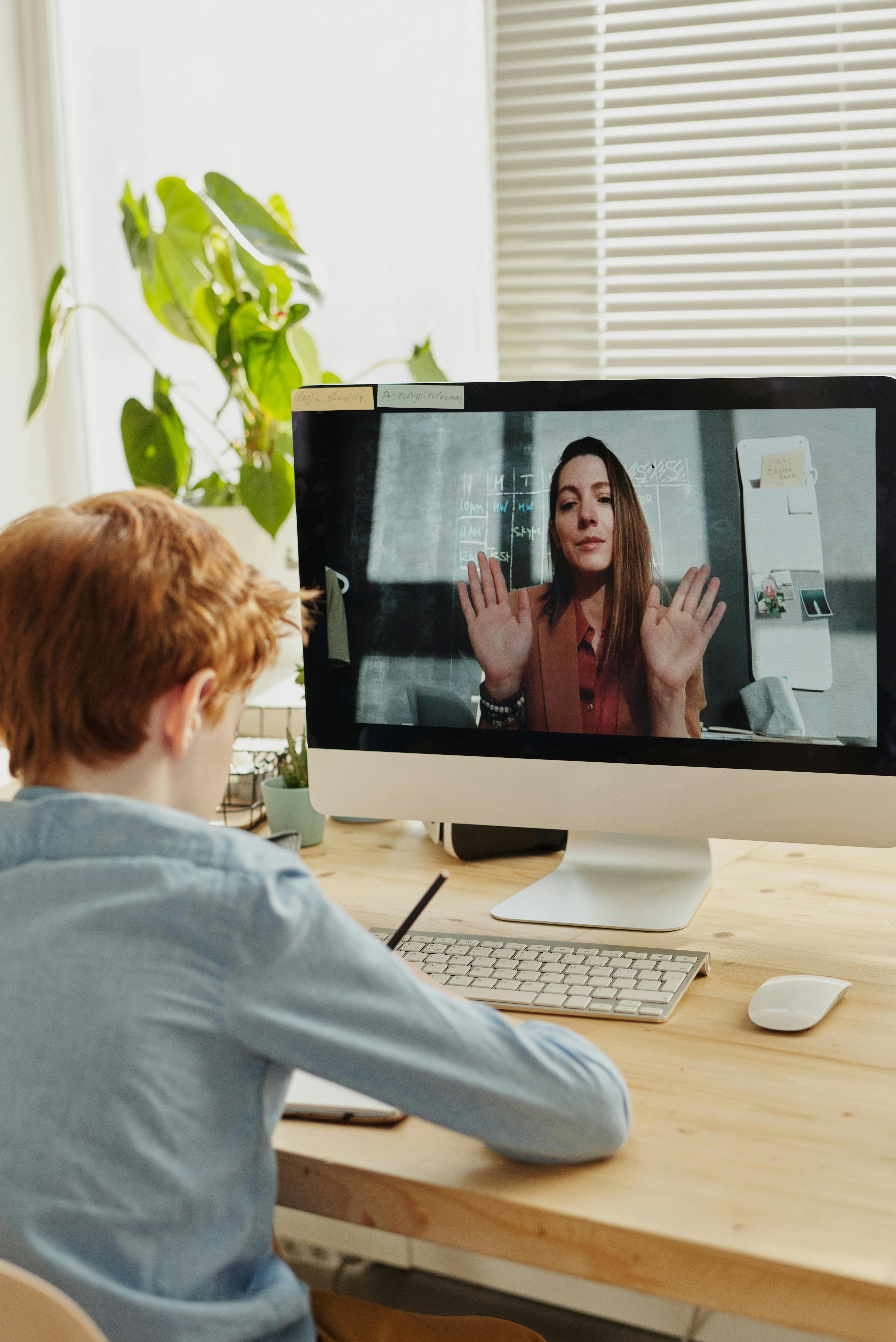 photo of boy video calling with a woman through imac