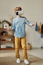 Boy in Blue Dress Shirt and Brown Pants While Using Vr Headset