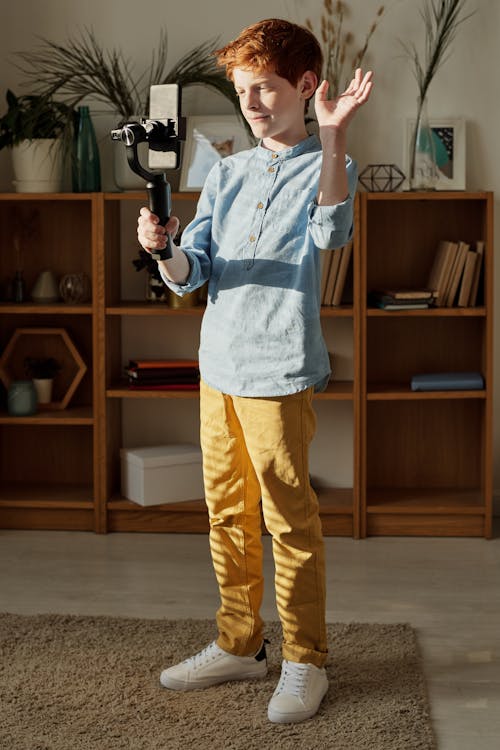 Photo of Boy Standing While Holding Black Selfie Stick