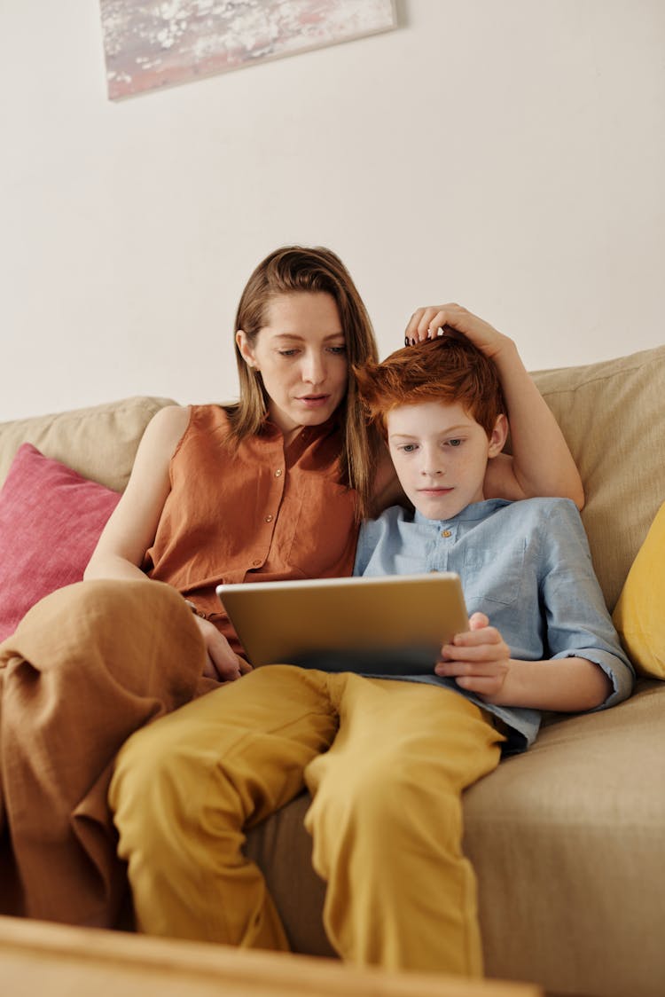 Photo Of Woman And Boy Watching Through Tablet Computer