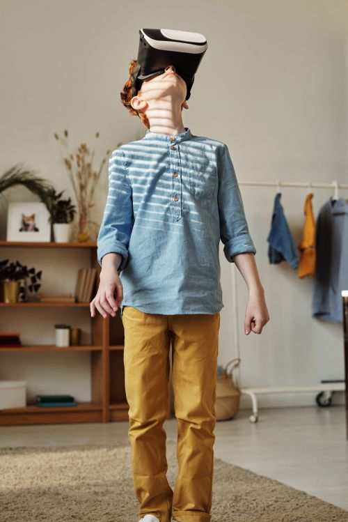 Free A young boy exploring a virtual reality experience indoors, wearing a VR headset. Stock Photo
