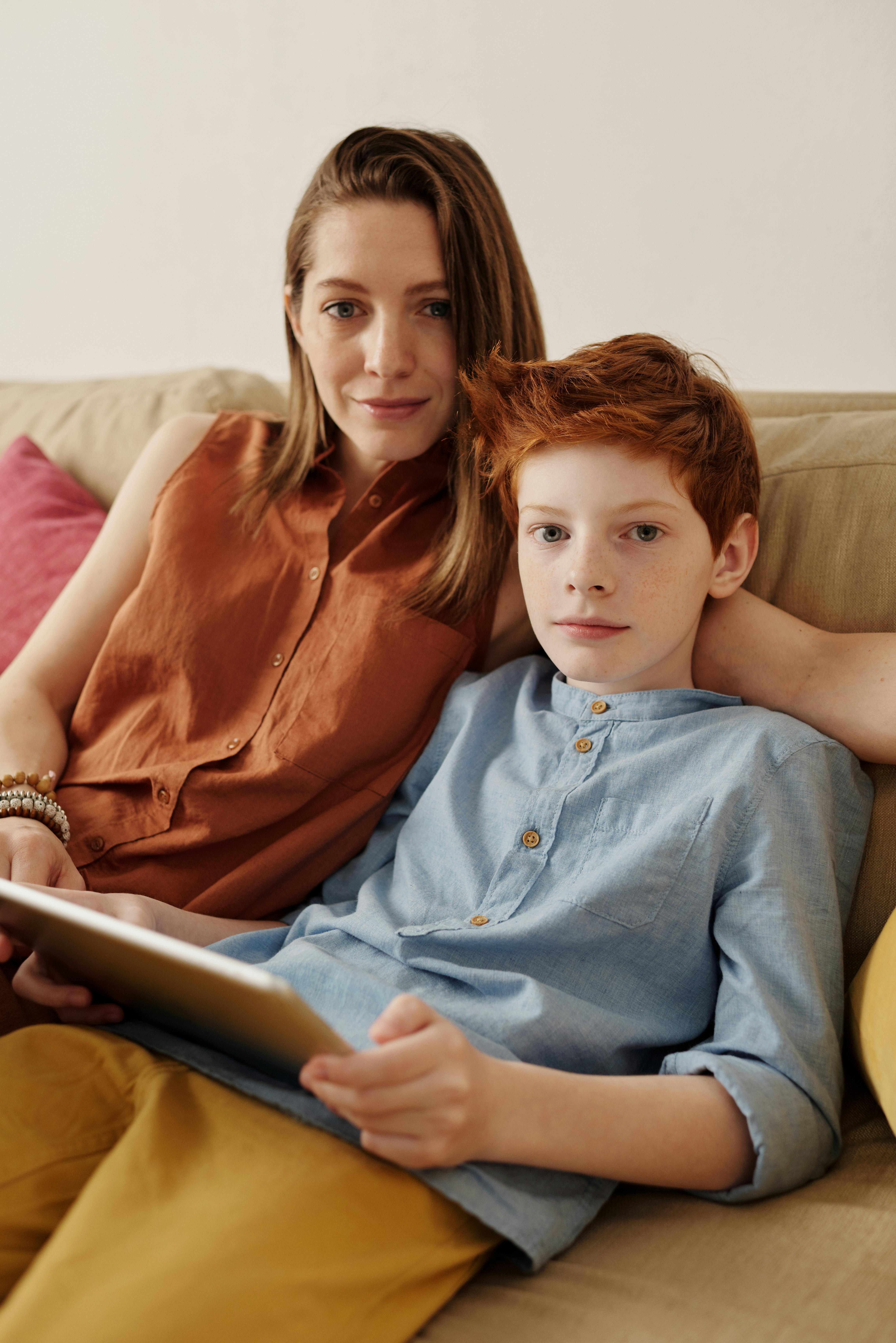 photo of woman and boy sitting on couch