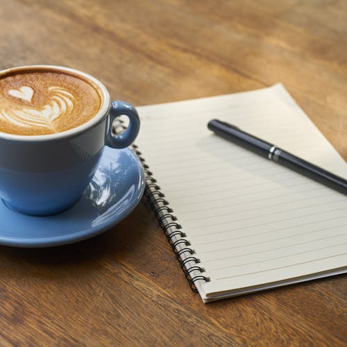 Coffee on Saucer Beside the Notebook