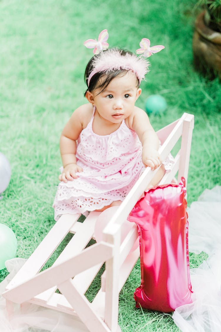 A Toddler Sitting On Bench