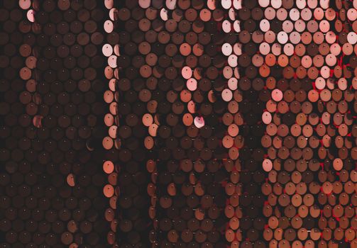 Close-up of copper sequins forming a shiny textured pattern. Ideal for abstract and decorative designs.