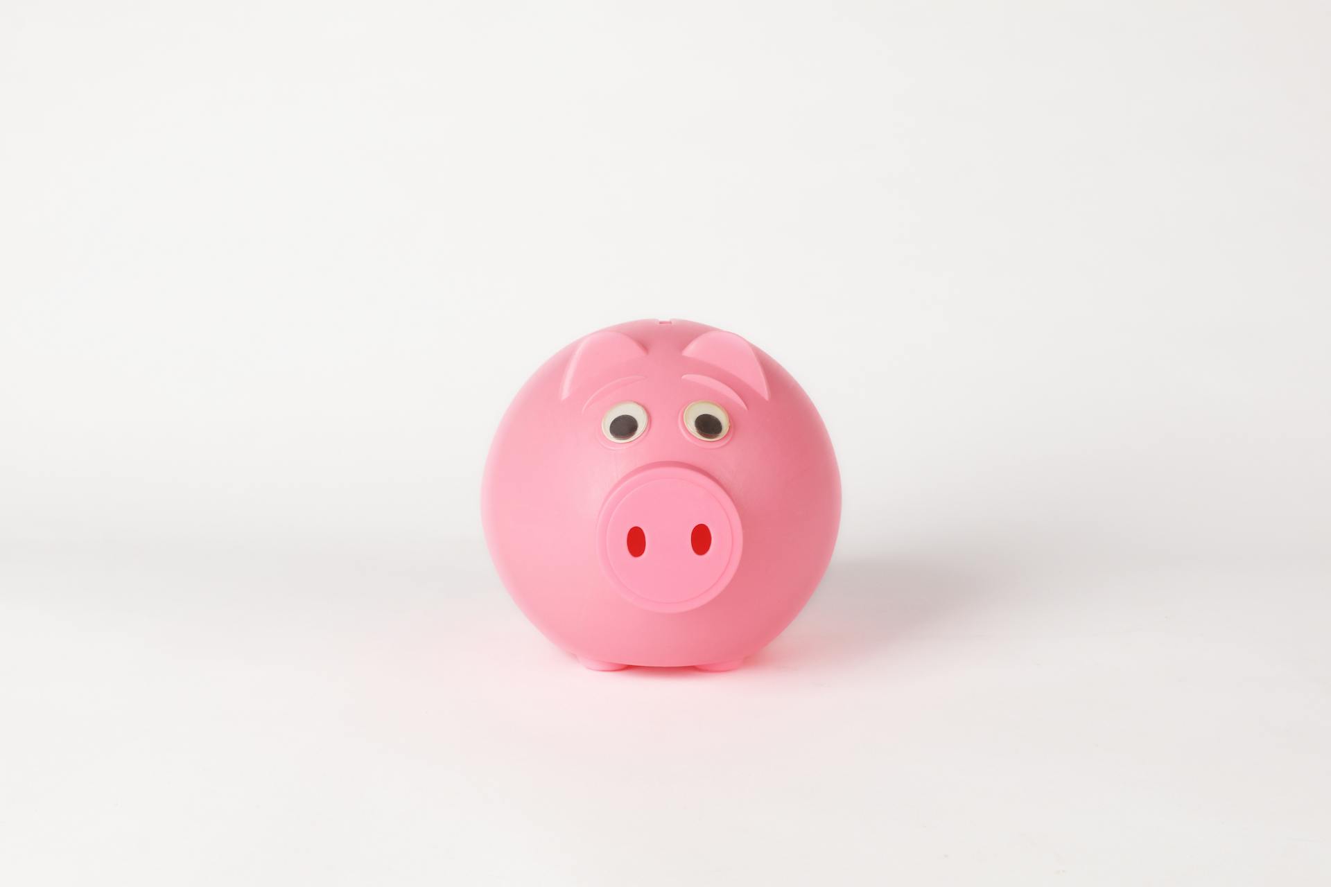 Cute pink piggy bank on a clean white background, symbolizing savings and finance concepts.