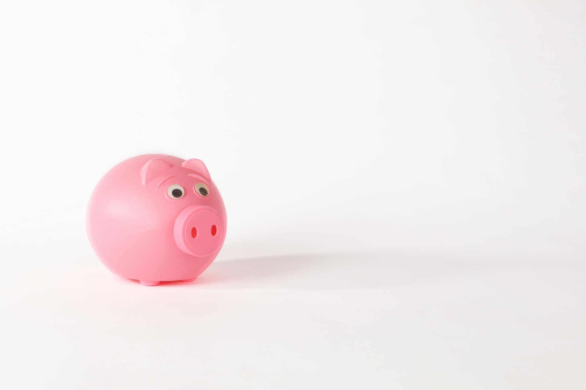 Cute pink piggy bank isolated on white background representing savings and finance concepts.