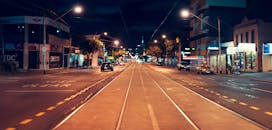 夜晚，繁华城市的街景中，有轨电车轨道与充满活力的灯光交相辉映