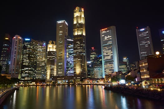 A breathtaking view of Singapore's illuminated skyscrapers reflecting on the river at night.