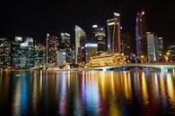 新加坡滨海湾的夜景倒映着照明摩天大楼和充满活力的灯光，构成城市天际线