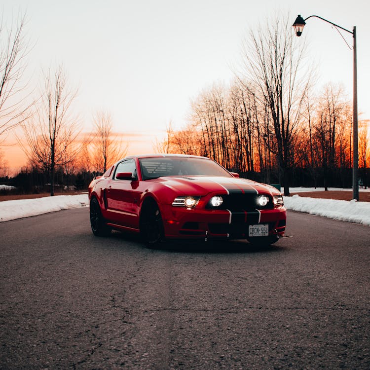 Red Sports Car On The Asphalt Road During Sunset