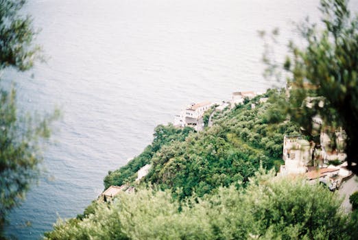 Lush green hills meeting the vast blue Tyrrhenian Sea on the Amalfi Coast, Italy.
