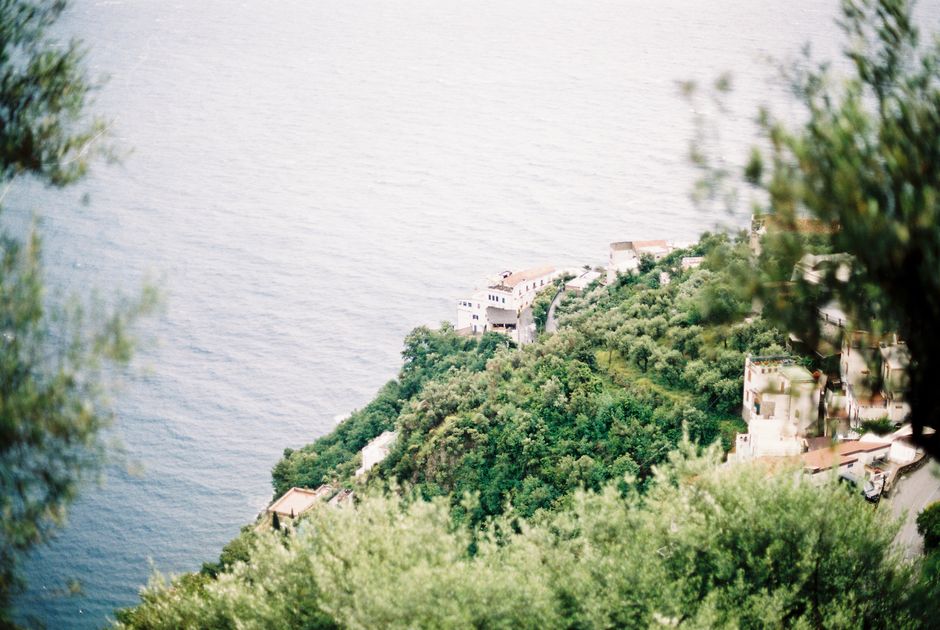 Lush green hills meeting the vast blue Tyrrhenian Sea on the Amalfi Coast, Italy.