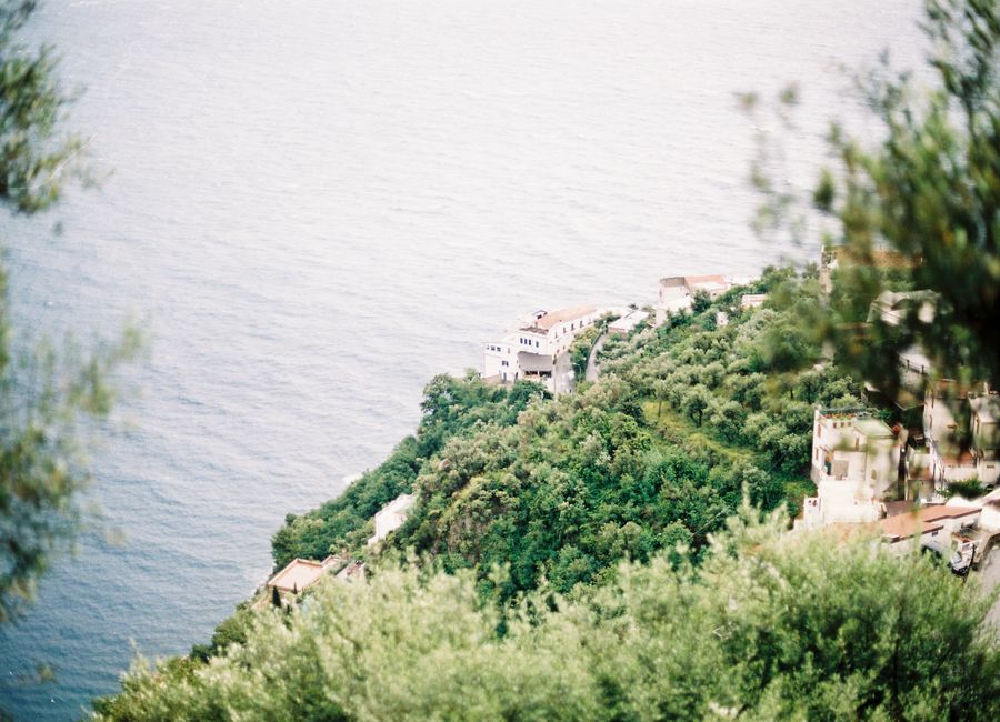 Lush green hills meeting the vast blue Tyrrhenian Sea on the Amalfi Coast, Italy.
