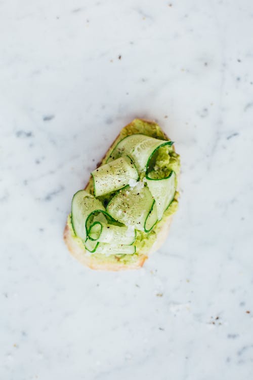 Free Avocado Toast with Cucumber Slices on Marble Table Stock Photo