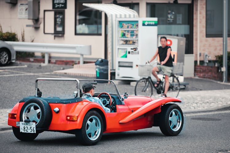 Man Driving Retro Red Sports Car On Street