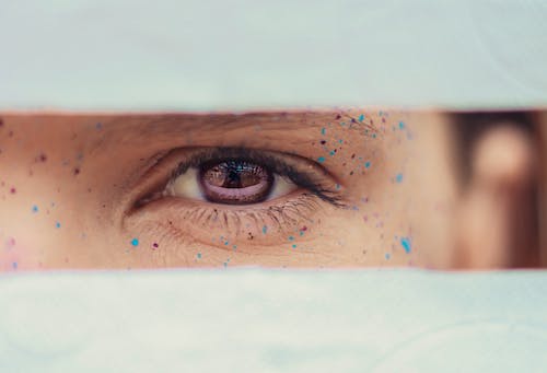 Free Crop woman brown eye with drops of paint on face Stock Photo