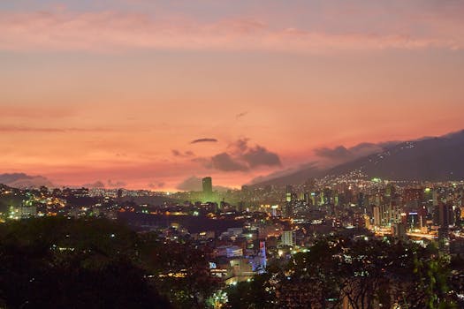 A breathtaking view of Caracas skyline at twilight with a vivid sunset backdrop.