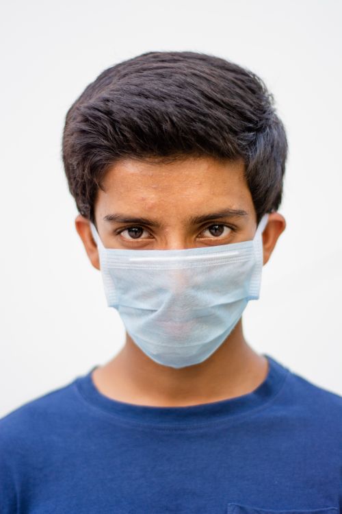 Free Close-up of a teenager wearing a surgical mask for pandemic protection. Stock Photo
