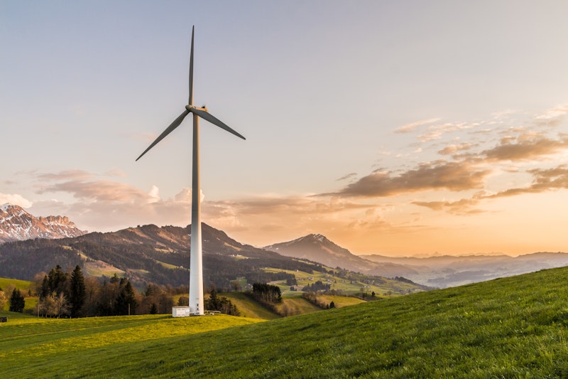 Wind turbines and solar panels against blue sky symbolizing renewable energy transition