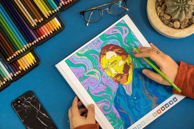 Colouring a surreal portrait page with pencils — photo by Charly Mova on Pexels