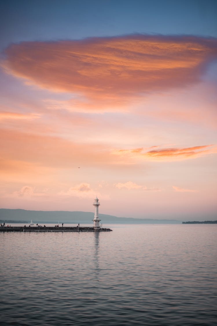 Lonesome Lighthouse On Pier Near Sea In Sunset Light