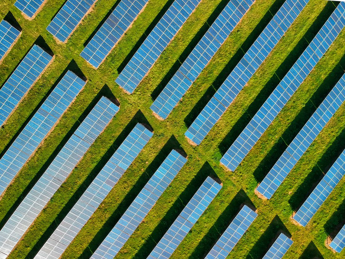 Aerial view of solar panels in a green field.