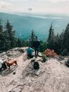 徒步旅行者和狗欣赏着宁静的山峰景观，凸显了户外冒险与自然的魅力