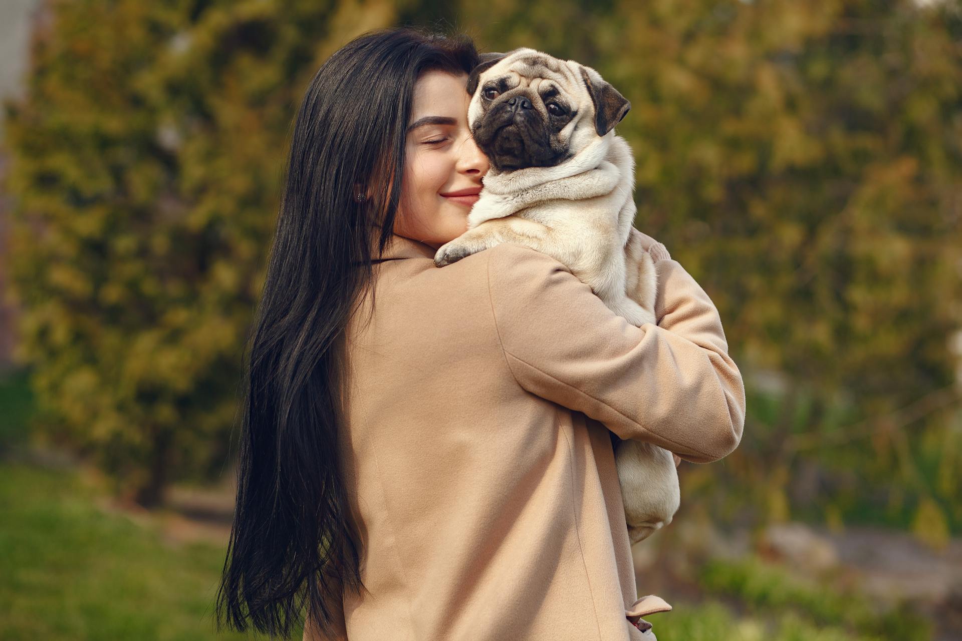 Happy woman with pug on hands