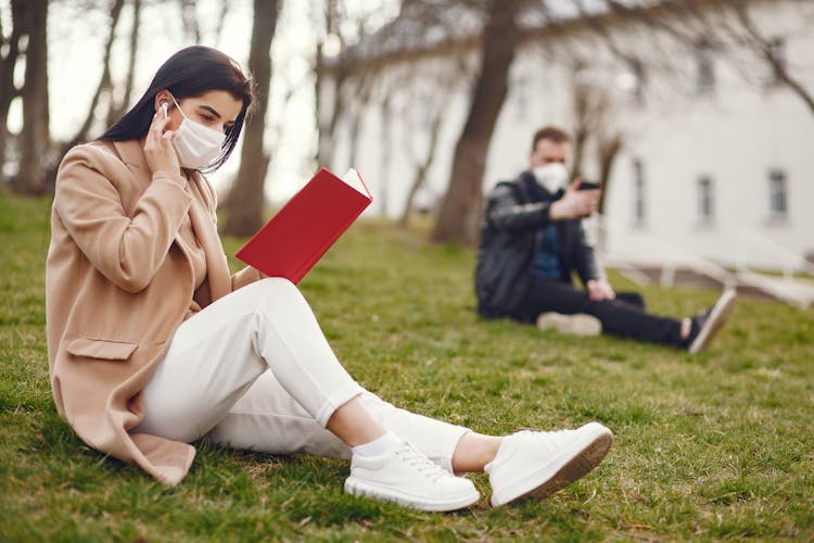 Young Woman Reading Book In Park