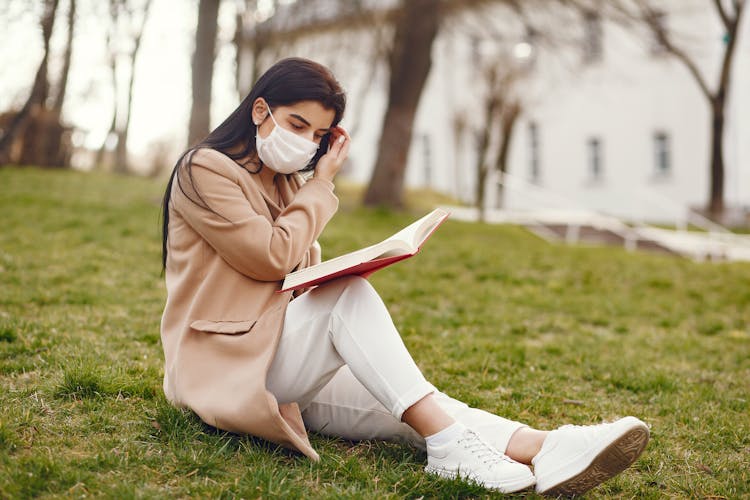 Charming Woman Reading Book On Lawn In Square